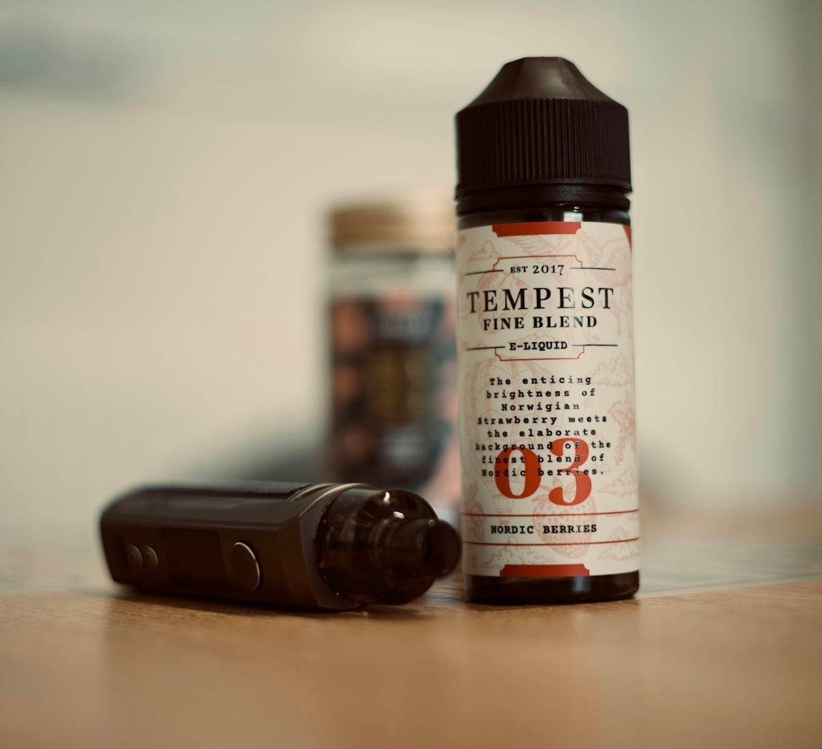 a bottle of e - liquid next to an electronic device